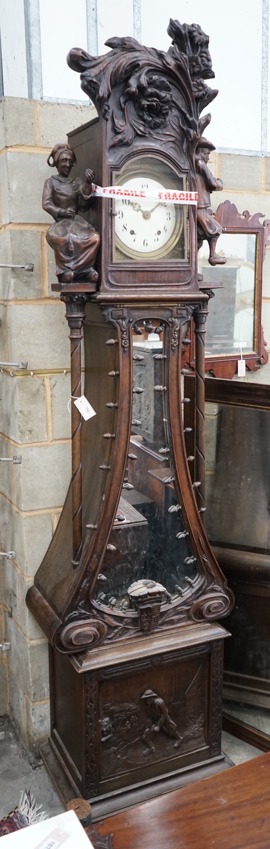 An early 20th century Flemish carved oak and walnut longcase clock, height 240cms.